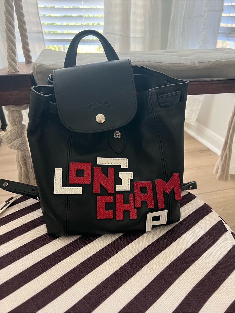 Longchamp Black Backpack with Red and White Lettering Appliqué